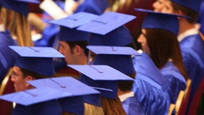 Graduates in caps and gowns in rows. 